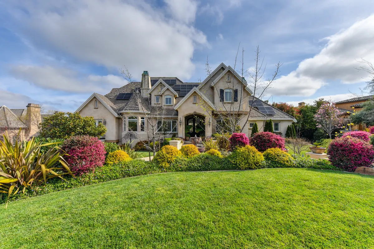 A suburban home with a lush lawn and landscaped flower beds